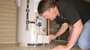 Plumber repairing drain pipe under kitchen sink during plumbing service